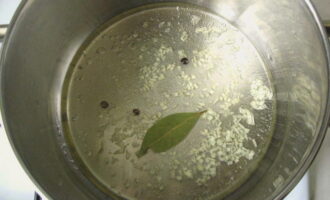 Ihanda ang marinade. Ibuhos ang isang litro ng malamig na tubig sa isang kasirola, ihalo ang asin at asukal sa loob nito, magdagdag ng mga black peppercorns, tinadtad na bawang at bay leaf. Pakuluan, lutuin ng 3-5 minuto, ibuhos ang isang kutsarita ng 70% na esensya ng suka at patayin ang kalan.