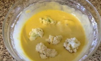 Ilagay ang mga cauliflower florets sa isang lalagyan na may batter at igulong ang mga ito sa batter sa lahat ng panig.