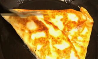 Painitin ng mabuti ang kawali sa mahinang apoy. Ibuhos sa isang maliit na halaga ng langis ng oliba. Ilatag ang tinapay na pita na nakatiklop sa isang tatsulok. Ilagay ang nakatiklop na gilid pababa at iprito hanggang sa maging golden brown sa magkabilang gilid.