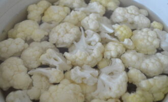 Dalhin ang inasnan na tubig sa isang pigsa sa isang kasirola at ihulog ang inihandang mga inflorescences ng cauliflower dito. Pakuluan ang laman ng kawali at lutuin ng pito hanggang walong minuto. Ang pulp ay hindi dapat pakuluan.
