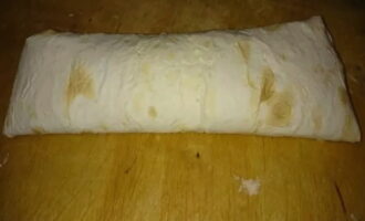 Pagulungin nang mahigpit ang tinapay na pita.