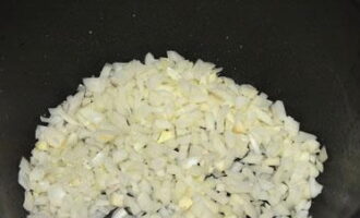 Curățați ceapa, clătiți sub jet de apă rece și tocați cu un cuțit ascuțit. Se toarnă puțin ulei vegetal în vasul multicooker și se adaugă ceapa tocată. Prăjiți ceapa până se înmoaie.