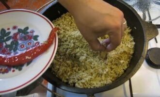 Verwijder de knoflook en hete peper uit de afgewerkte pilaf.