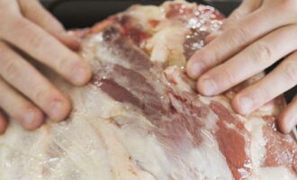 Frecati bine toata carnea cu ulei de masline, sare si piper dupa gust. Dacă aveți un suport de sârmă, puneți piciorul pe el și așezați-l pe o tavă de copt; dacă nu, puteți face fără el.