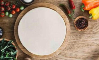 Bột bánh pizza mỏng kiểu bánh pizza đã sẵn sàng. Bạn có thể dùng bột làm đế để nướng bánh pizza.