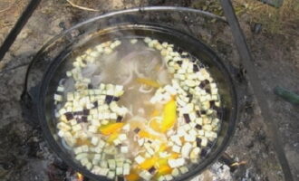 Tăiați vinetele în cubulețe mici și puneți, de asemenea, în ceaun. Nu este nevoie să curățați legumele.