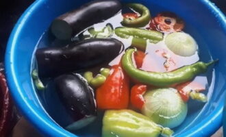 Hoe Georgische ajapsandali koken volgens het klassieke recept? Maak eerst de groenten klaar. Was de aubergines, paprika en chilipepers goed. Schil de uien.
