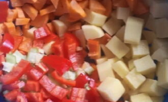 Schil de aardappelen en wortels met een dunschiller. Snijd ze vervolgens in middelgrote blokjes. Droog de paprika, schil hem, verwijder het klokhuis en snijd hem in blokjes. Was de tomaten goed, droog ze, snijd ze in blokjes en verwijder eerst de steel. Snijd ook de gepelde ui in blokjes.