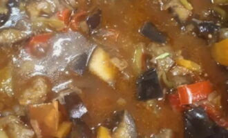 Zet de ketel op middelhoog vuur en verwarm goed. Giet er een beetje olijfolie bij en voeg dan één voor één de groenten toe - uien en wortels, bak tot ze goudbruin zijn en voeg dan de aubergines en paprika's toe. Stuur dan de aardappelen en tomaten. Snijd de chilipeper in kleine stukjes en voeg toe aan de groenten.