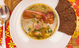 Aboqui la sopa de pèsols calents amb costelles fumades en bols. Serviu el plat a taula juntament amb pa o galetes. Bona gana!