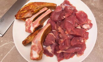 Separem les costelles fumades individualment, si cal. Talleu la carn de porc a daus petits.
