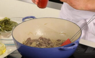 Treceți castraveții murați prin răzătoare. Adăugați-le în carne împreună cu ceapa. Gatiti pana cand ceapa devine usor maronie. Apoi adăugați pasta de tomate și amestecați.