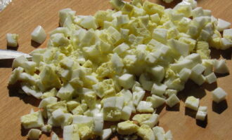 Magdagdag ng pinong tinadtad na pinakuluang itlog at sariwang pipino sa mangkok ng salad.