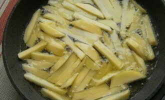 Aboqueu oli vegetal a la paella i deixeu-ho escalfar. Després, submergiu les patates en oli bullint i saleu-les. Aboqueu oli vegetal a la paella i deixeu-ho escalfar. Després, submergiu les patates en oli bullint i saleu-les.