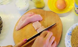 Hoe kipnuggets thuis koken? Verwijder het vel van de kipfilet en verwijder vervolgens het bot. Droog de resulterende filet met keukenpapier en snijd hem in de lengte doormidden.Elke filetplaat snijden we in langsstroken, die vervolgens dwars op de korrel in kortere stukken worden verdeeld. Op deze manier worden plano's voor rechthoekige klompjes verkregen.
