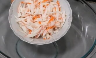 Paano maghanda ng salad ng Red Sea na may crab sticks? I-defrost ang crab sticks nang maaga, pagkatapos ay gupitin ang mga ito sa manipis na piraso at ilagay ang sangkap sa isang malalim na mangkok ng salad.
