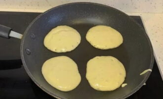 Painitin ng mabuti ang isang makapal na ilalim na kawali. Sandok ang kuwarta sa isang maikling distansya. Lutuin sa katamtamang init hanggang lumitaw ang mga bula sa ibabaw ng pancake at lumapot ang batter. Painitin ng mabuti ang isang makapal na ilalim na kawali. Sandok ang kuwarta sa isang maikling distansya. Lutuin sa katamtamang init hanggang lumitaw ang mga bula sa ibabaw ng pancake at lumapot ang batter.