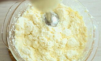 Apoi, adăugați brânza de vaci pre-măcinată și bateți conținutul cu un mixer sau blender.