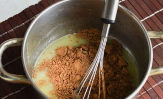 Voeg cacao toe aan het hete mengsel. Klop met een garde.
