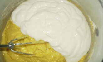 És millor triar crema agra espessa. Afegiu la crema agra a la massa i barregeu bé la massa. Ha de ser llis, gruixut i uniforme.