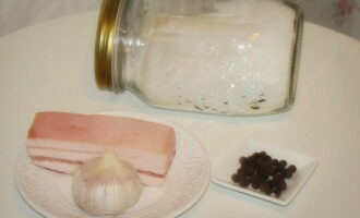 Hoe reuzel thuis te drogen met knoflook? We wassen een stuk vers reuzel en vegen het af met keukenpapier. Laten we zout en kruiden bereiden.