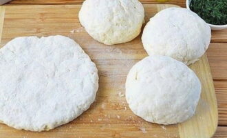 Verdeel het deeg in vier delen en rol dunne koeken uit. Leg in het midden van elk platbrood een beetje geraspte kaas, rol het deeg tot een bal en rol het opnieuw uit.