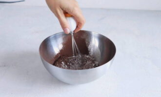 Cum se face prajitura cu mousse cu trei ciocolata dupa reteta clasica acasa? Mai întâi, pregătiți pandișpanul de ciocolată. Într-un recipient, amestecați făina, cacao, praful de copt și sarea până se omogenizează.