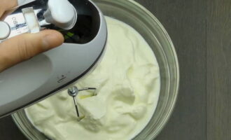 Hur gör man en banankaka utan bakning med gräddfil? På hög hastighet, vispa gräddfilen med en mixer tills den bildar ett stabilt skum. Tillsätt strösocker och en tesked vaniljessens till den förtjockade gräddfilen. Och fortsätt att vispa med en mixer i flera minuter. 
