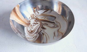 Adăugați cantitatea necesară de smântână în ganache și amestecați folosind o spatulă de silicon. 