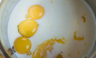 Upang ihanda ang cream, ibuhos ang gatas sa isang makapal na pader na kasirola, idagdag ang mga yolks at talunin hanggang sa maging homogenous ang masa at lumitaw ang mga bula ng hangin sa ibabaw. 