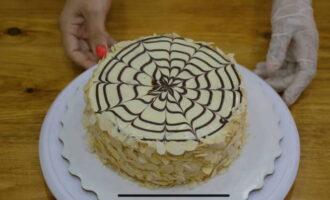 Să începem să decoram desertul. Incepem sa acoperim blatul tortului cu dulceata de caise. Trebuie să topim ciocolata albă. Acest lucru se poate face folosind o baie de apă.O turnam peste desert. Așteptăm până când ciocolata albă începe să se întărească. Apoi topește laptele. Îl aplicăm pe stratul superior folosind o pungă de gătit și desenăm spirale. Folosind o scobitoare sau alt obiect subțire (de exemplu, un cuțit), trageți cu atenție linii drepte, începând de la centrul tortului și terminând la margini. Pe marginile desertului asezam petale de migdale. După aceasta, nu ezitați să-l puneți la frigider pentru aproximativ 3-4 ore. Așteptați puțin și veți putea încerca acest tort divin! 