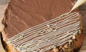 Ilapat ang chocolate cream sa ibabaw ng cake, iwisik ang mga gilid ng dessert na may mga karagdagang mumo na natitira pagkatapos putulin ang mga cake. Palamutihan ang tuktok ng cake na may cream, na naglalarawan ng mga bulaklak, mata o alon. 