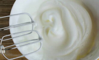 Magdagdag ng sitriko acid at asin sa mga inihandang mainit na puti, talunin ng isang panghalo hanggang sa makuha ang isang matatag na puting bula. 
