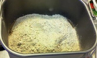 Hoe bak je thuis heerlijk brood in een broodmachine? Giet plantaardige olie in de emmer van de broodmachine en vet de deegmengmessen er lichtjes mee in. Voeg ook melk en gezeefd tarwe- en roggemeel toe.