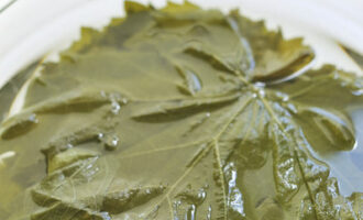 Upang maghanda ng dolma ayon sa klasikong recipe, hugasan ang mga dahon ng ubas at ibuhos ang tubig na kumukulo sa loob ng 5-7 minuto. Pagkatapos ay ilagay ang mga dahon sa isang colander upang maubos. Alisin ang mga petioles mula sa mga dahon.