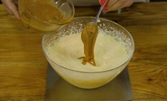 Începem să batem treptat untul moale cu un mixer, adăugând masa de lapte-gălbenuș în porții mici. Apoi combinați amestecul cu untul de nuci și bateți până la omogenizare. 