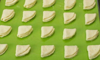Aplaneu lleugerament els triangles resultants, torneu a submergir un costat en sucre i col·loqueu-los sobre pergamí o estora de silicona amb el costat dolç cap amunt. Poseu la safata de forn amb les galetes resultants al forn, preescalfat a 200 ̊C i deixeu-hi 25 minuts.