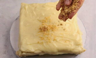 Muntar el pastís. Col·loqueu els pastissos uns sobre els altres i unteu-los amb flam. Espolseu molles per sobre del pastís.