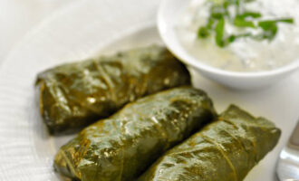 Ilagay ang kawali sa kalan, pakuluan ang sabaw, pagkatapos ay bawasan ang apoy at lutuin ang dolma sa loob ng 1-1.5 na oras. Alisin ang natapos na dolma mula sa apoy at hayaan itong magluto ng 10-15 minuto. Ihain nang mainit kasama ang sarsa na iyong pinili.
