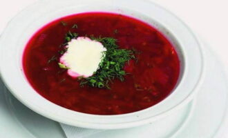 Serviu borscht clàssic amb crema agra i herbes. 