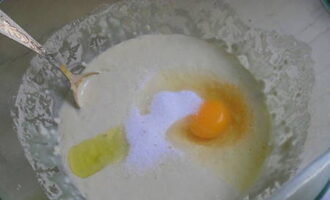 Adăugați o lingură de ulei vegetal și un ou în aluatul crescut, amestecați amestecul până la omogenizare.