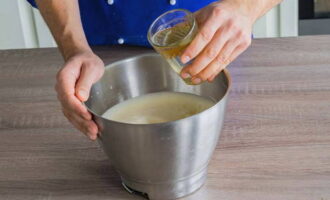 I en separat skål, vispa äggen med vanligt socker och vaniljsocker med en mixer tills en fluffig, homogen massa bildas. Häll sedan i vegetabilisk olja och blanda väl igen. 