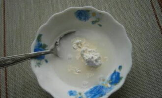 Col·loqueu midó en un plat petit. Ompliu-lo amb dues cullerades d'aigua freda.