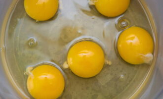 Hoe maak je een donzige gestoomde omelet? Neem een ​​diepe kom en breek elk ei erin met de scherpe kant van een mes.