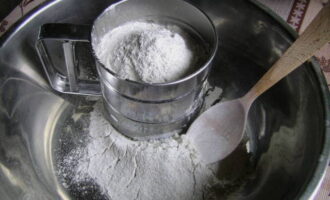Cum se prepară aluatul de lapte pentru plăcinte? Cerneți făina printr-o sită într-un castron mare. Acest lucru se face astfel încât să fie îmbogățit cu oxigen, iar plăcintele noastre să fie pufoase și aerisite.