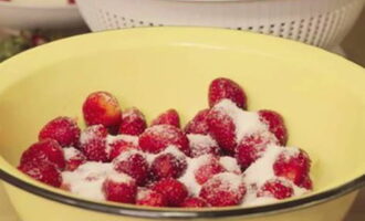 Upang gumawa ng strawberry jam na may buong berries para sa taglamig, hugasan ang mga strawberry at alisin ang mga sepal. Alisan ng tubig sa isang colander at hayaang maubos ang tubig. Pagkatapos ay ilipat ang mga berry sa isang enamel bowl, magdagdag ng kalahati ng asukal at mag-iwan ng 3 oras.