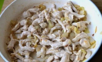 Ilagay ang mga piraso ng manok sa sibuyas at iprito hanggang maluto.