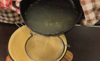 Un cop cuits els trossos de peix, els retirem, filtrem el brou per un colador i el tornem a posar al foc.
