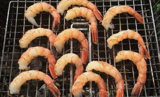 Plaats een rooster op de grill met kolen. We verdelen er langoustines in kruiden over.Kook ongeveer 5 minuten op hoog vuur van het vuur.