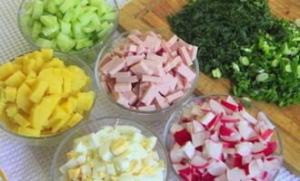 Om okroshka met worst op kwas volgens het klassieke recept te bereiden, bereidt en wast u de nodige groenten.Snijd radijsjes, komkommers, gekookte aardappelen, eieren en worst in blokjes van ongeveer dezelfde grootte.